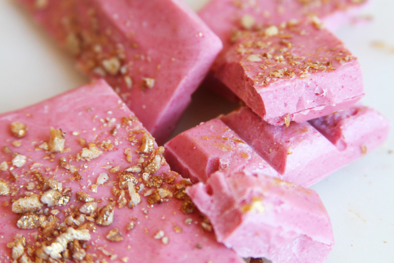Rosa chokladkaka med guldglänsande nötcrunch