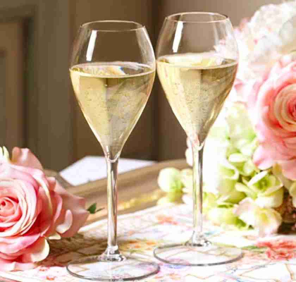 Champagneglas i plast 2st tillsammans med blommor p bord