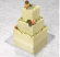 Tårta i 3 delar byggd av 3 fyrkantiga kakor med smörkrämoch blommor