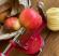 Röd äppelskalare från moster hulda med äpple och skalade, skivade äpplen
