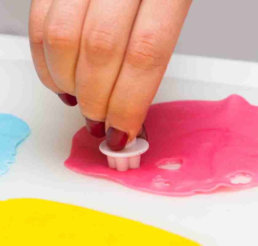 tar ut liten blomma i cerise sockerpasta