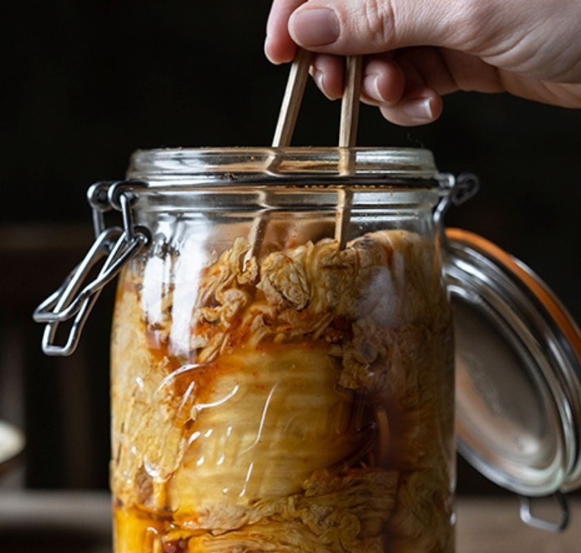 Plockar kimchi ur konserveringsburken