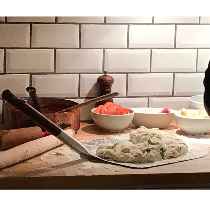 pizzaspaden p� b�nk med br�d som ska gr�ddas