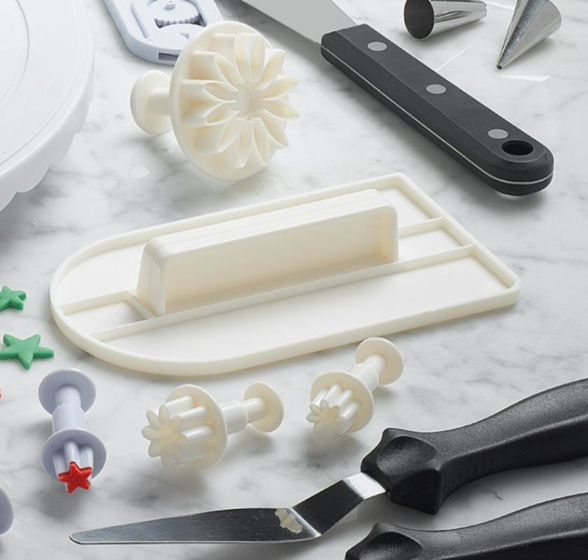 Vit t�rtspackel i plast p� bakbord  med andra bakverktyg