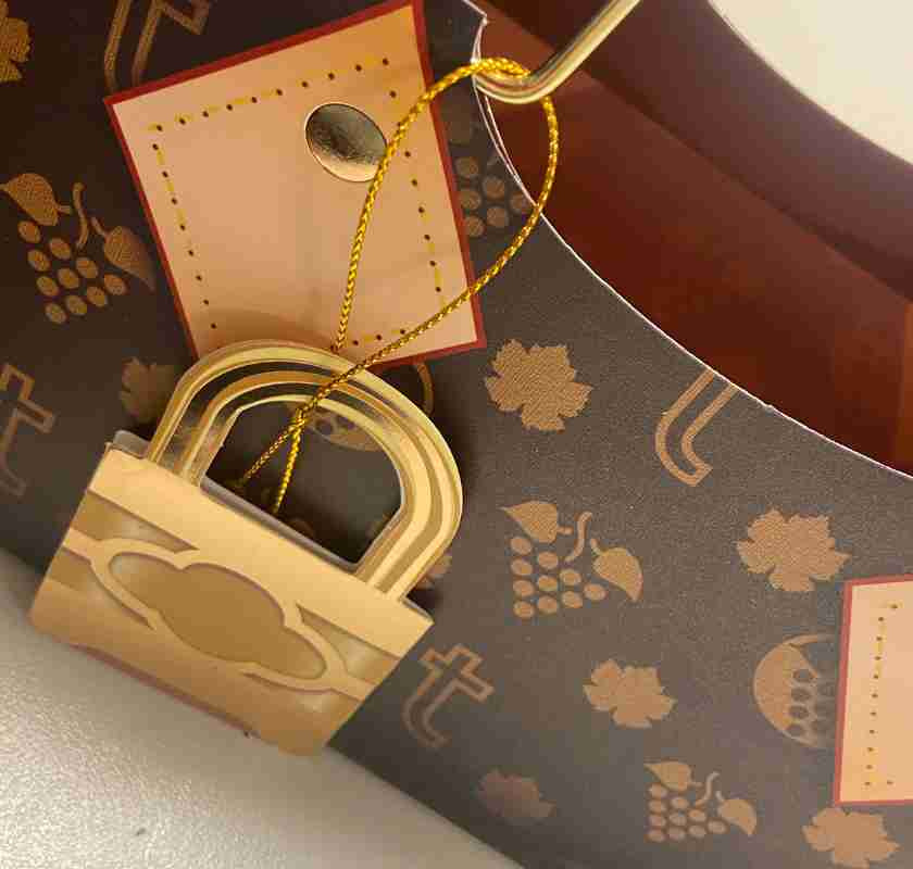  Detalj av framsidan med h�ngl�setikett p� prestigev�ska f�r flaskor, True Logo Purse Bag