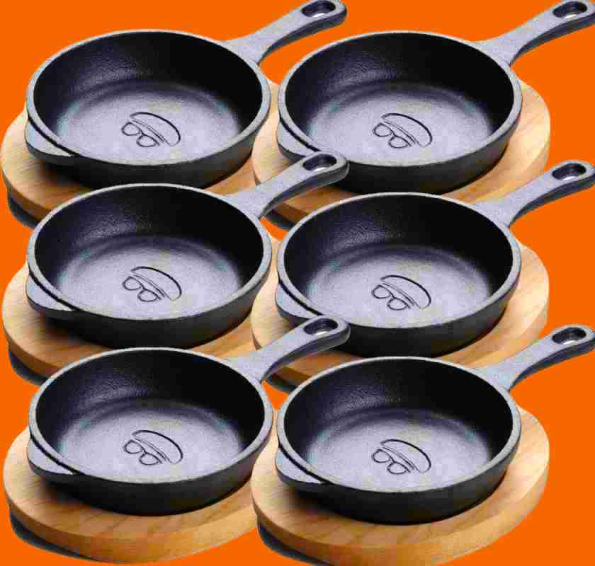 6 st minipannor i gjutj�rn med underl�gg i tr� mot orange bakgrund