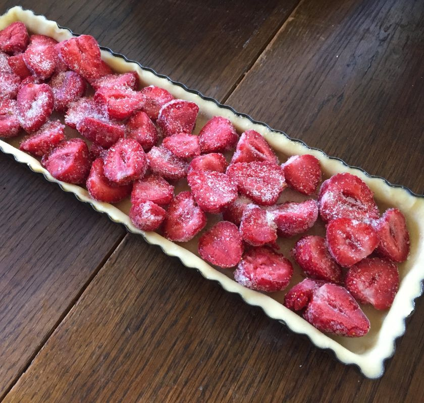 avl�ng pajform i metall fylld med pajdeg och jordgubbar