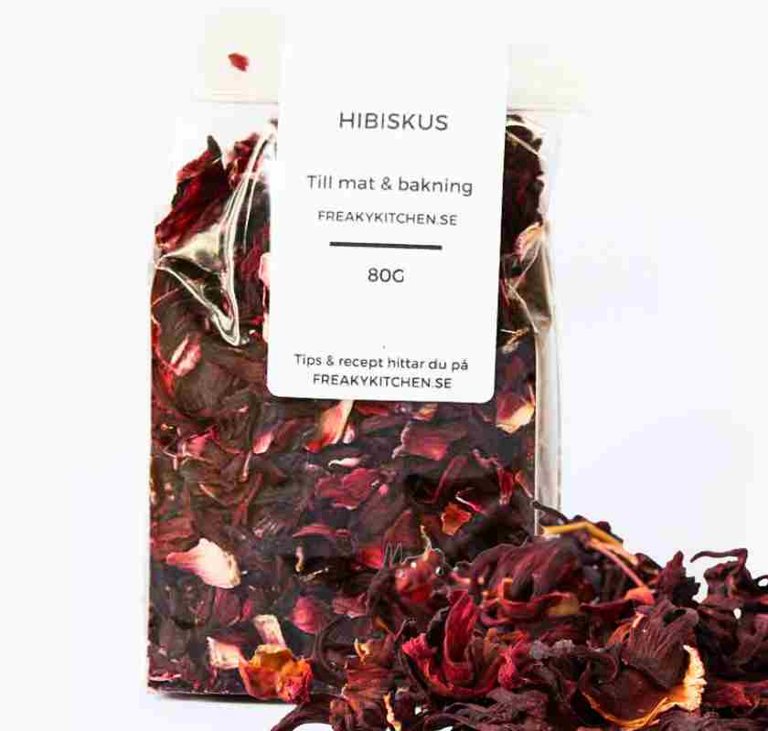 Hibiskusblomma torkad i cellofanp�se och p� bordet framf�r p�sen