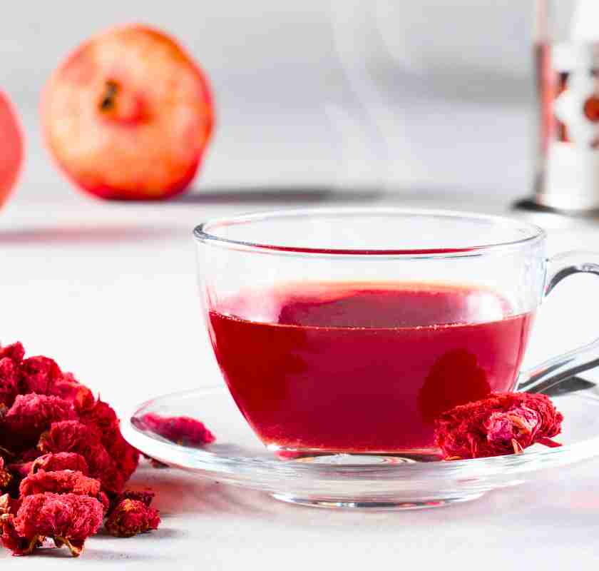 Torkade granat�ppelblommor som te i kopp av glas