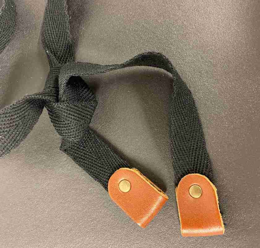 Detalj av knytband till barnf�rkl�de i svart skinn Xapron