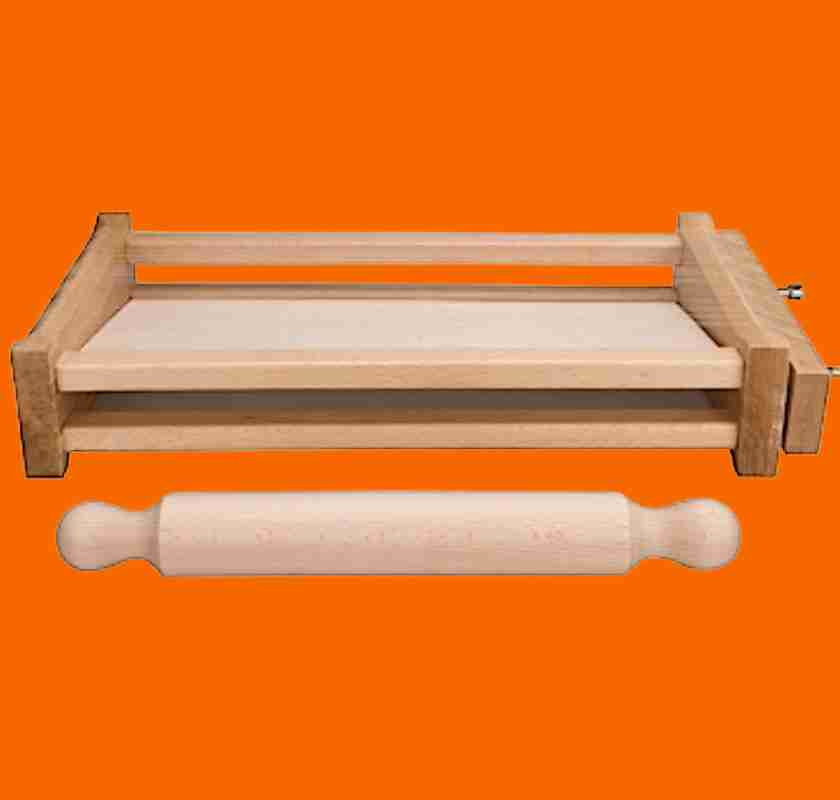 Chitarra med kavel f�r pastatillverkning mot orange bakgrund