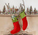 2 julstrumpor hänger på renhorn på spiselkrans