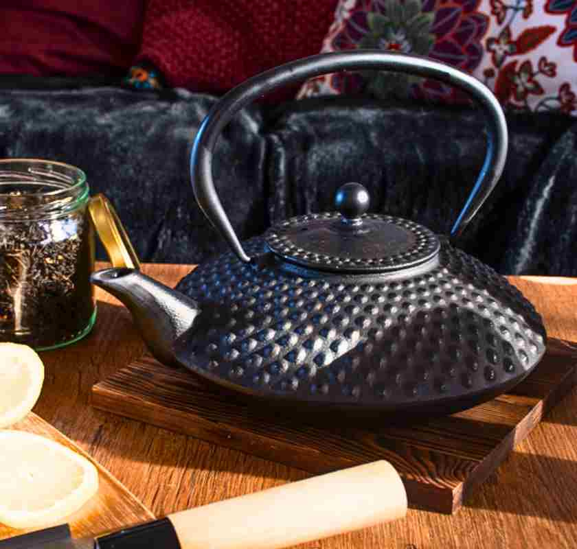 Tekanna japansk svart i gjutj�rn p� bord