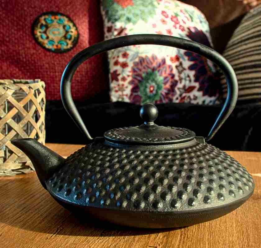 Tekanna japansk svart i gjutj�rn fr�n sidan st�r p� bord