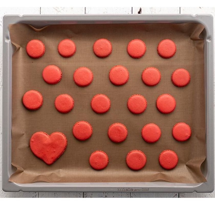 R�da vackra kakor p� bakpl�tspapper p� en ugnspl�t