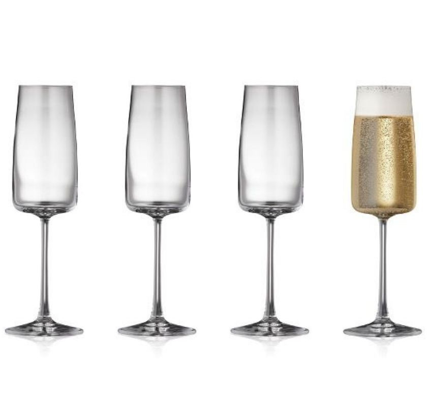 Fyra riktigt snygga champagneglas, ett fyllt med mousserande vin.