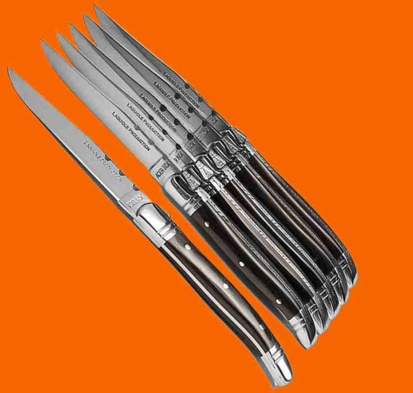 Grillknivar Laguiole med svarta handtag mot orange bakgrund