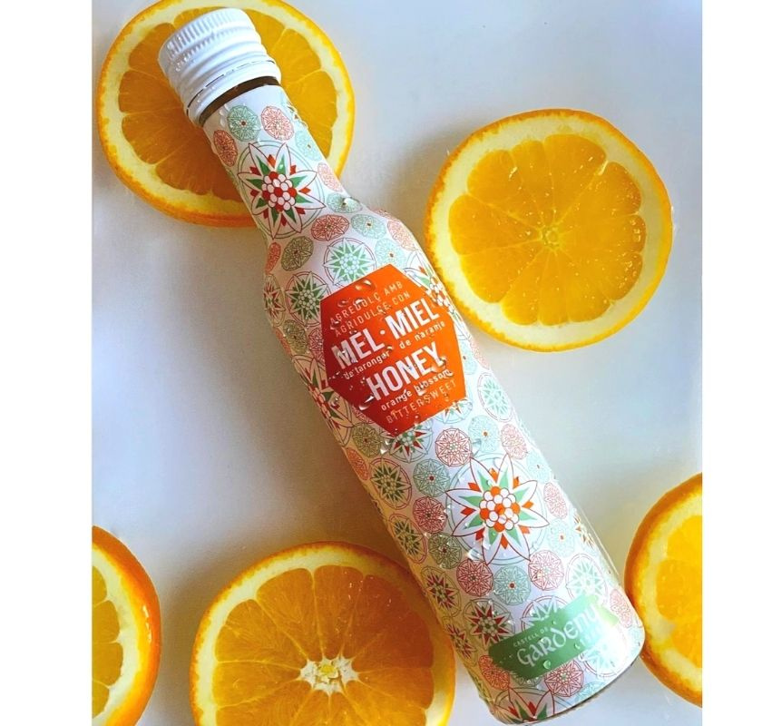 Flaska med apelsin- och honungsvin�ger p� apelsinskivor