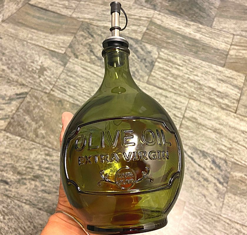 olivoljeflaska i gr�nt glas med pip av metall