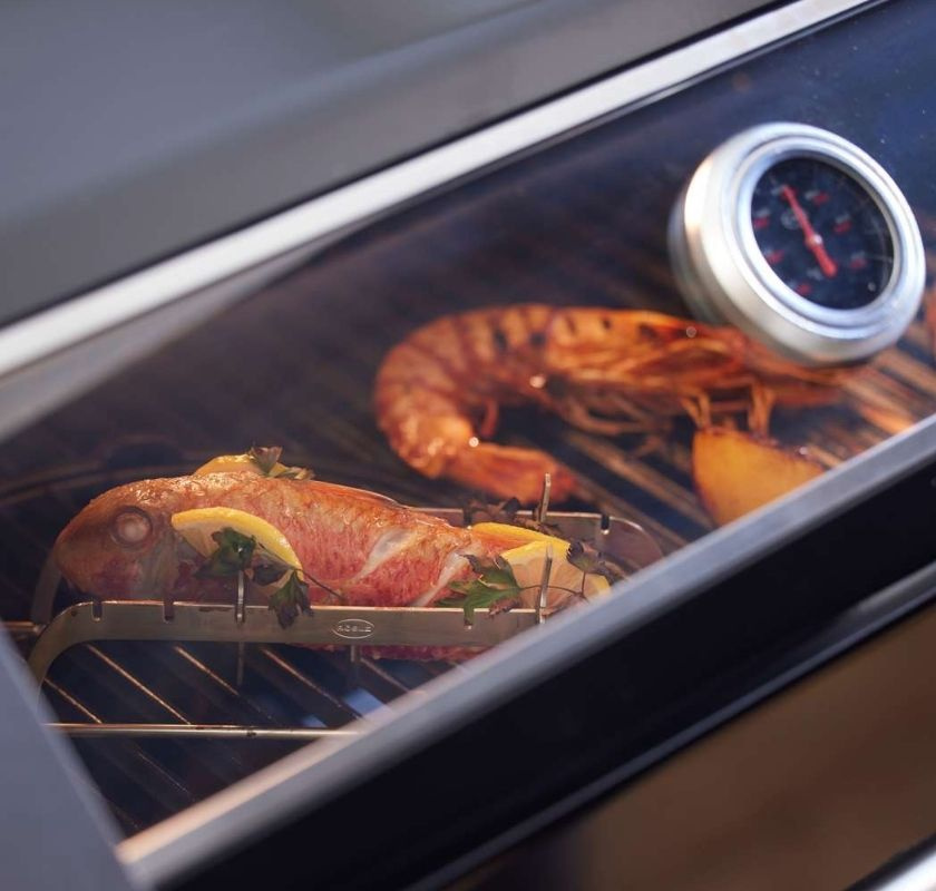 H�llaren med fisk p� grillen tillsammans med en hummer