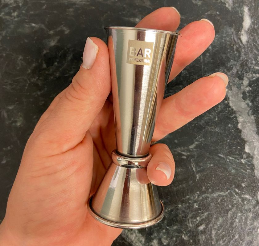 Jigger m�tglas i hand