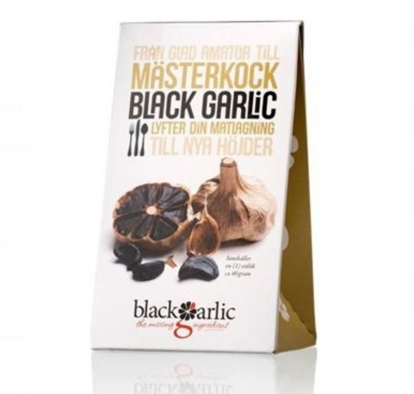 Förpackning av Black Garlic med text och illustrationer av svart vitlök. Färgglad design som beskriver produktens användning i matlagning.