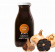 Blackgarlicketchup och svart vitlök En glasflaska med black garlic ketchup står framför svart vitlök och vanlig vitlök. Flaskans etikett är orange och vit.