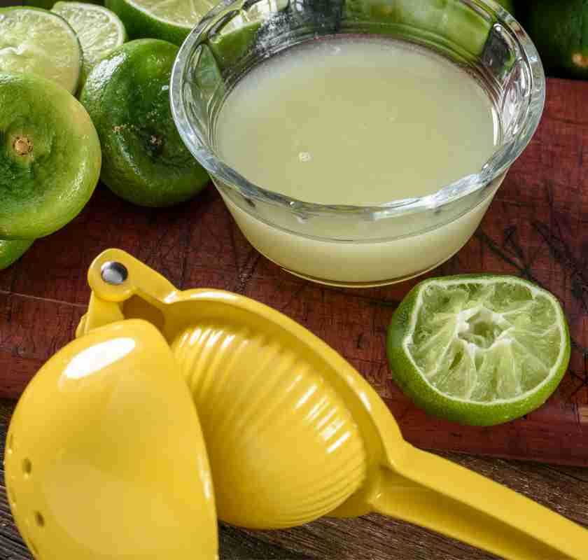 Limepress och juice i sk�l samt urpressade lime