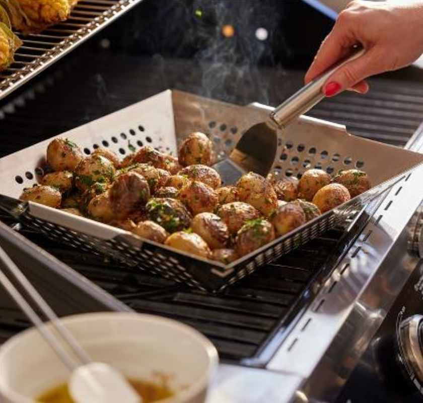 Grillkorg i rostfritt st�l med potatisar p� grillen