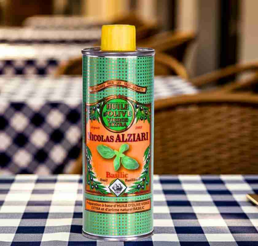 Basilikaoljan p� ett restaurangbord med bl�rutig duk