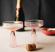 Rosa champagneglas 2st med kork i förgrunden och butelj i bakgrunden