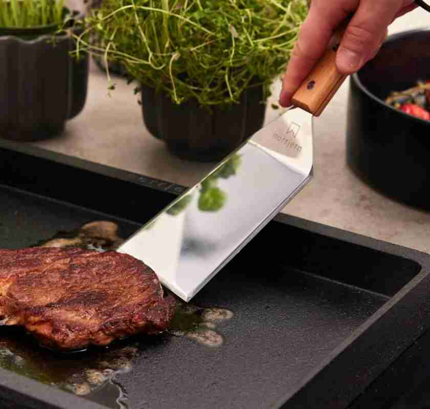 Stekh�ll queen med k�tt som v�nds med en stor hamburgerspade