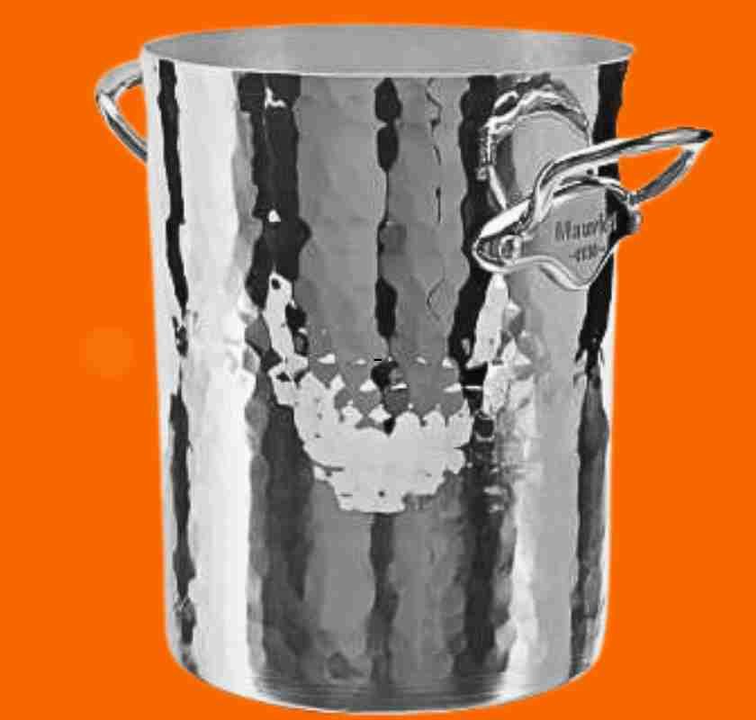 Mauviel champagnekylare h�g i hamrad aluminium mot orange bakgrund