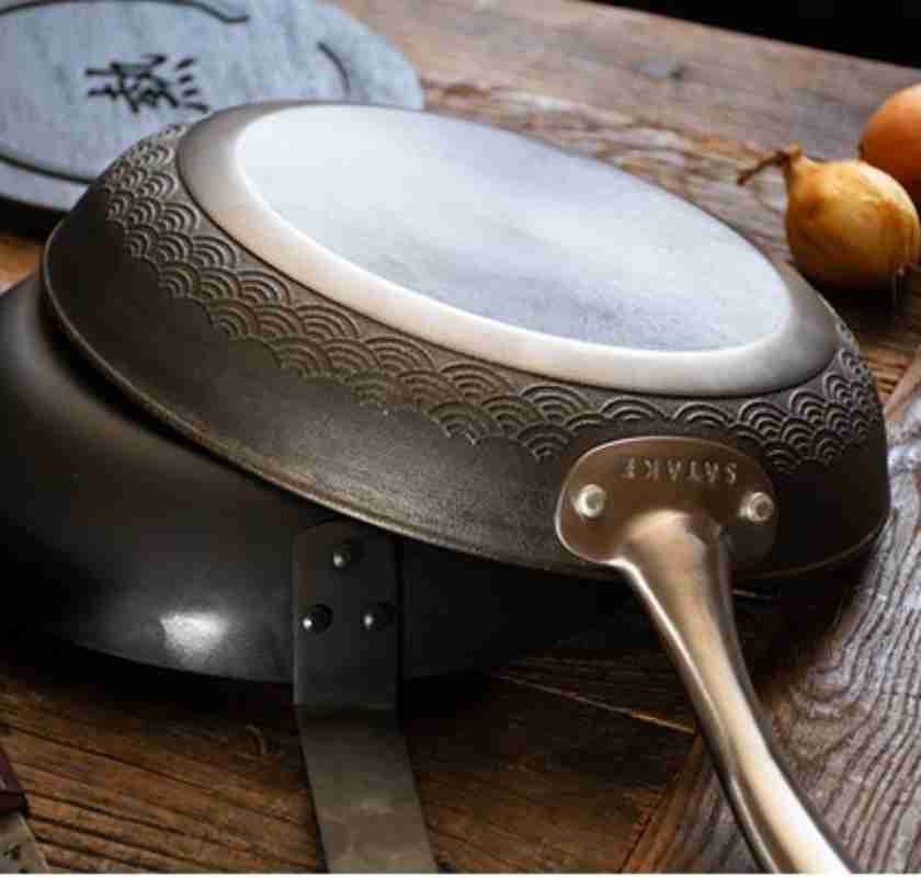 Satake Pure Pan stekpanna i h�rdat gjutj�rn 24 cm upp och ned ovanp� en kolst�lspanna