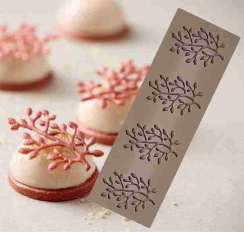 Tuile-form gren med bakelse i bakgrunden