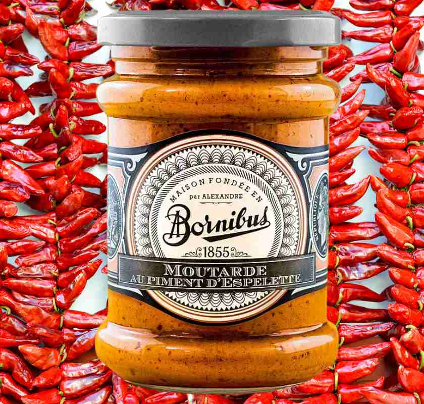 Espelettesenap fr�n Bornibus i glasburk med espelettepeppar i bakgrunden
